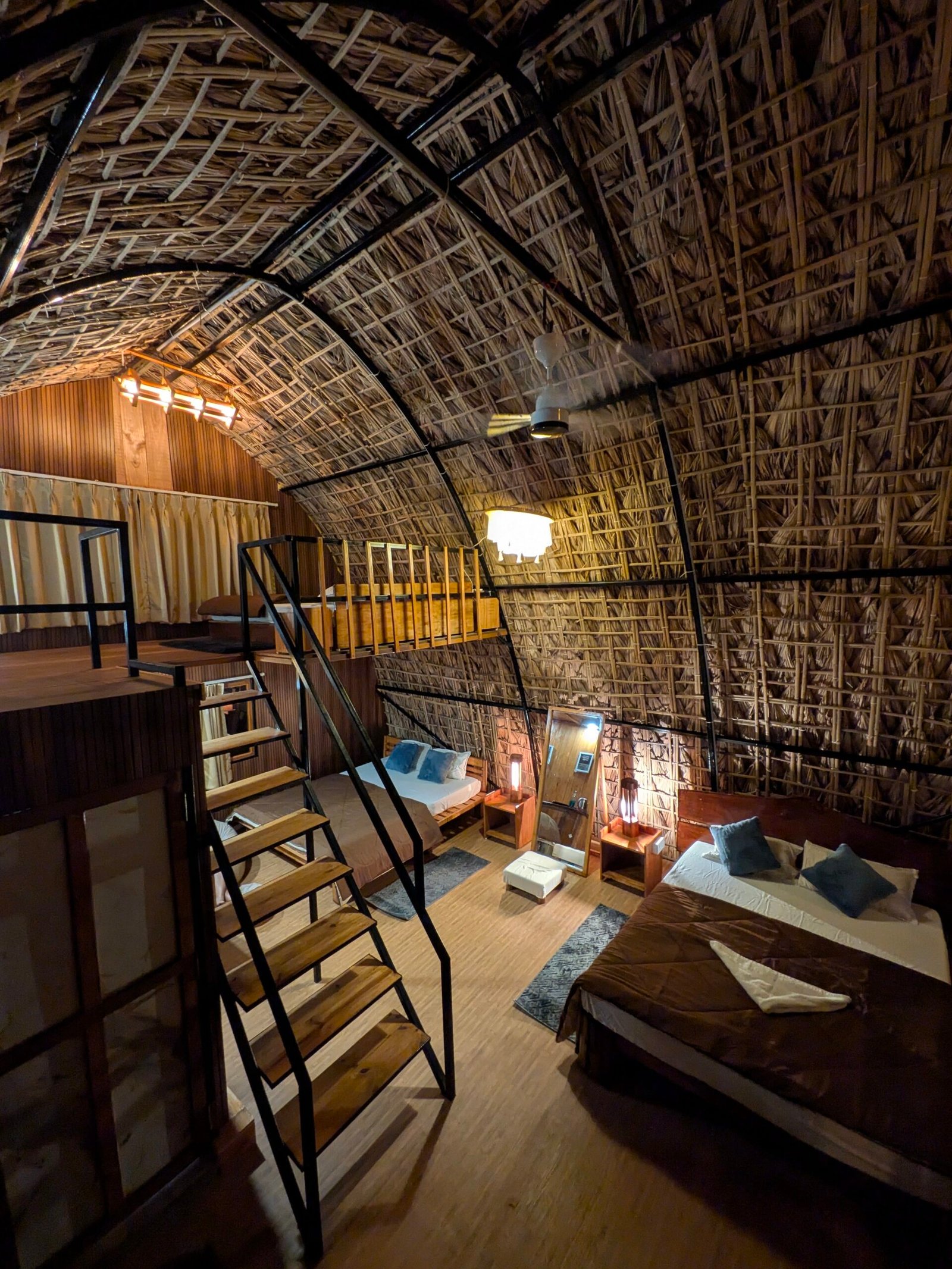Staircase leading to the loft, with the bathroom door open and beds visible below